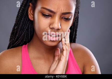 Nette junge afrikanische Frau hat Zahnschmerzen Stockfoto