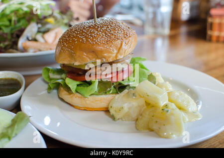 Hamburger, Hähnchen und Bratkartoffeln auf dem Teller. Stockfoto