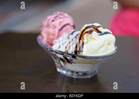 Close up Detailansicht leckere Schokolade und Karamell Eis mit Schokoladensauce auf Glas Schale serviert. Stockfoto