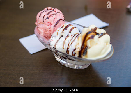 Close up Detailansicht leckere Schokolade und Karamell Eis mit Schokoladensauce auf Glas Schale serviert. Stockfoto