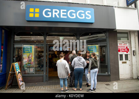 West Wales. Haverford West. Bridge Street. Die Menschen in der Warteschlange außerhalb Greggs. Stockfoto