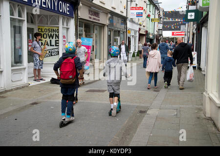 West Wales. Haverford West. Bridge Street. Kinder auf Rollern. Stockfoto