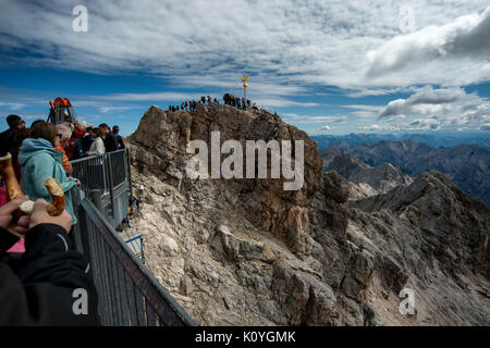 Touristen, die in die Warteschlange des Gipfels der Zuspitze Berg auf dem Deutschland Österreich Grenze zu erhalten. Auf 2962 m ist er der höchste Berg Deutschlands. Stockfoto