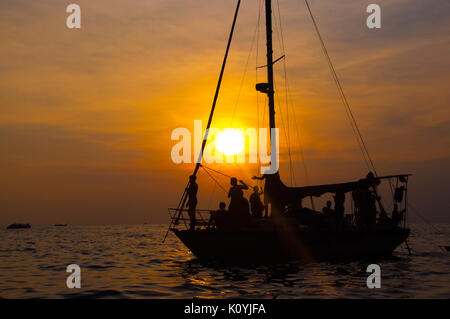Segelboot Sonnenuntergang Fantasy ist ein Boot mit vollen Segeln gegen eine bunte orange sky Foto Silhouette Stockfoto