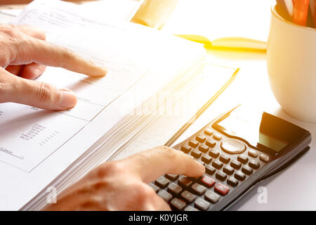 Finanzdaten analysieren. Einsparungen, Finanzen, Wirtschaft. Nahaufnahme der Hand zählen ein Geschäftsmann auf Rechner im Büro oder zu Hause. Soft Focus Stockfoto
