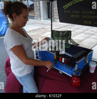 Airbrush Künstler mit Farben an Street Fair Stockfoto