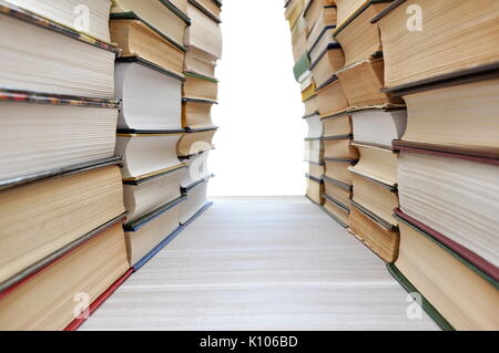 Stapel von Büchern einen Korridor mit weißen Copyspace am Ende Stockfoto