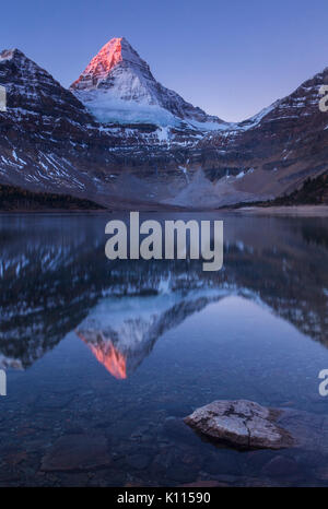 Frühe Licht auf Mount Assiniboine über dem Lake Magog in Mount Assiniboine Provincial Park, Rocky Mountains, British Columbia, Kanada. Stockfoto