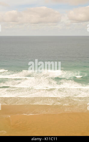 Das Meer und Sand bis Waschen am Strand in der Brandung und Leistungsschalter und Sandstrand, klares Wasser auf der kornischen Küste mit Wolken im Himmel und Wellen Stockfoto