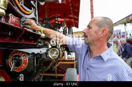 Shaun Garrod aus Norfolk, hilft die Garrett Showman 'Invincible' Polnischen während des Tages eine der großen Dorset Steam Fair im Tarrant Hinton, Dorset. Stockfoto