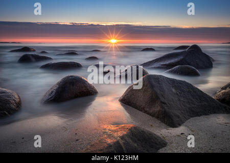 Szenische Ansicht vom Strand mit Steinen und Sonnenuntergang im Sommer Nacht auf den Lofoten, Norwegen Stockfoto