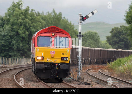 Klasse 66 66044 der DB Cargo mit einem Güterzug in Kirkby Stephen Station auf dem Einleben und Carlise Bahnstrecke. Cumbria England mit einem Sempahore Stockfoto