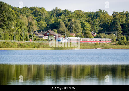 Personenzug auf dem Weg nach Göteborg, mit Kopenhagen als Endziel, vorbei an der Nähe zum Wasser am See Sävelången in Floda, Schweden, Europa Model Release: Nein Property Release: Nein. Stockfoto