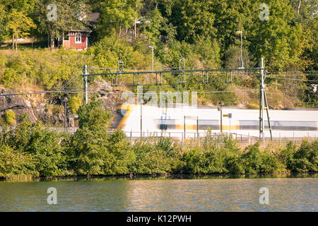 High speed S-Bahn auf dem Weg nach Göteborg aus Vänersborg vorbei in der Nähe der Wasser am See Sävelången in Floda, Schweden, Europa Model Release: Nein Property Release: Nein. Stockfoto