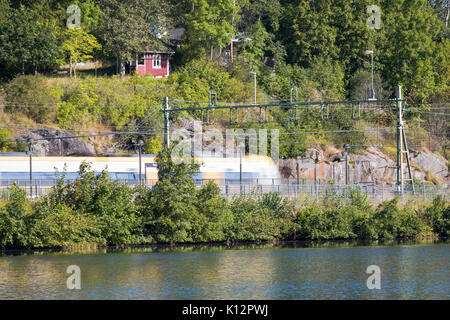 High speed S-Bahn auf dem Weg nach Alingsås aus Göteborg vorbei in der Nähe der Wasser am See Sävelången in Floda, Schweden, Europa Model Release: Nein Property Release: Nein. Stockfoto