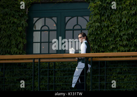 Ein Kellner an einem Fenster für die Mitglieder Gehäuse im Centre Court in Wimbledon Championships 2017 Stockfoto