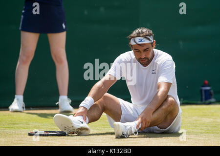 Marcos Baghdatis aus Zypern sitzt auf dem Boden, nachdem Sie das Gentlemen's Singles - Wimbledon Championships 2017 rutscht Stockfoto