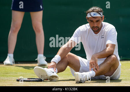 Marcos Baghdatis aus Zypern sitzt auf dem Boden, nachdem Sie das Gentlemen's Singles - Wimbledon Championships 2017 rutscht Stockfoto