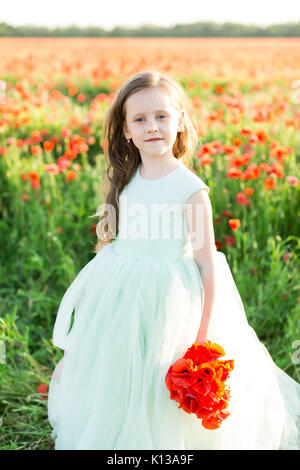 Hochzeit, fest, Schönheit, Kid Mode, Stil Konzept - im Licht der Sonne schöne Mädchen mit braunem Haar zu tragen fair ärmelloses Kleid holding Bündel von poppy Stockfoto