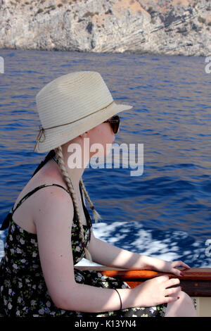 Blick auf die junge Frau auf Boot tragen Sonnenhut Stockfoto