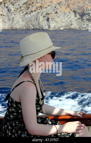 Blick auf die junge Frau auf Boot tragen Sonnenhut Stockfoto