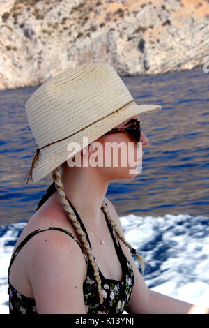 Blick auf die junge Frau auf Boot tragen Sonnenhut Stockfoto