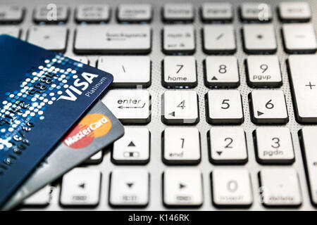 Bangkok, Thailand - 24. August 2017: Nahaufnahme von 2 Kreditkarten VISA und Mastercard auf Laptop mit ENTER-Taste. Stockfoto