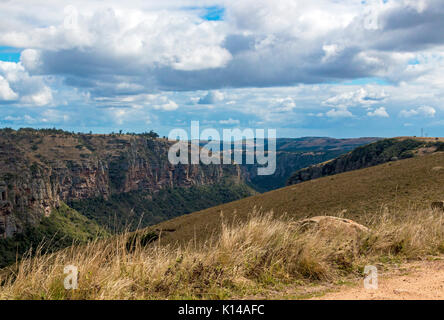 Blick vom Lake Eland Game Reserve von Trockenrasen Klippen Berge und Täler gegen den blauen bewölkten Himmel Landschaft bei Oribi Gorge in Südafrika Stockfoto