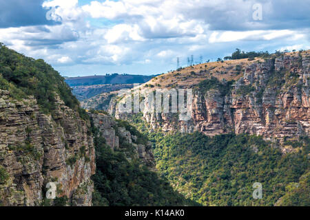 Blick vom Lake Eland Game Reserve von grünen Bäumen, Felsen Berge und Täler gegen den blauen bewölkten Himmel Landschaft bei Oribi Gorge in Südafrika Stockfoto