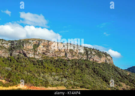 Blick vom Lake Eland Game Reserve der grünen Bäume und Felsen gegen den blauen bewölkten Himmel Landschaft bei Oribi Gorge in Südafrika Stockfoto