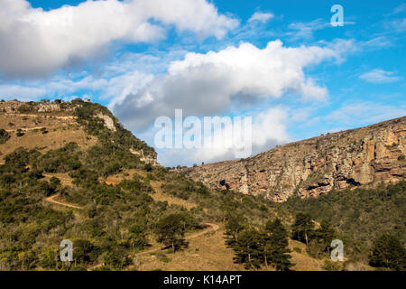 Blick vom Lake Eland Game Reserve von Trockenrasen Bäume Klippen Berge und Täler gegen den blauen bewölkten Himmel Landschaft bei Oribi Gorge in Südafrika Stockfoto