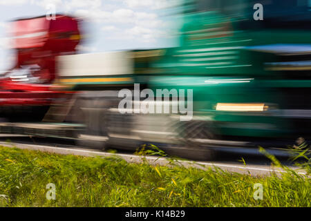 Lkw-Transport auf der Straße mit Bewegungsunschärfe. unscharfes Bild Hintergrund. bunte Tapete mit kopieren. Stockfoto