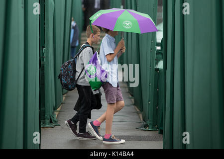 Tennis Fans mit einem Wimbledon Schirm im Regen an der Wimbledon Championships 2017 Stockfoto