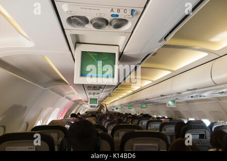 In einem Flugzeug/innen ein Flugzeug Kabine mit Monitor Fluglage Karte Anzeige auf dem TV-Bildschirm zeigt die Position des Flugzeuges über/über Frankreich. Stockfoto