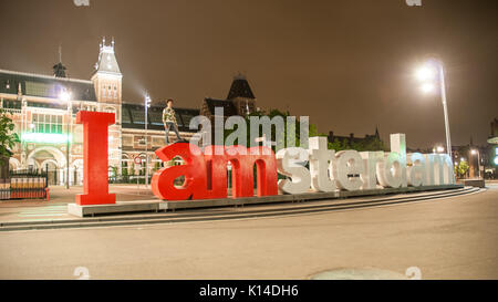 AMSTERDAM - April 2014: das Rijksmuseum Amsterdam Museum mit den Worten ich Amsterdam und Menschen posieren, den Niederlanden. Nachtsicht, lange exposur Stockfoto