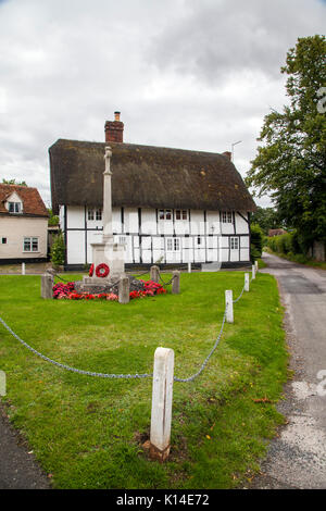 Kriegerdenkmal auf dem Dorfplatz mit schwarzen und weißen Fachwerkhaus mit Reetdach in Dorchester auf Themse Oxfordshire halbieren Stockfoto