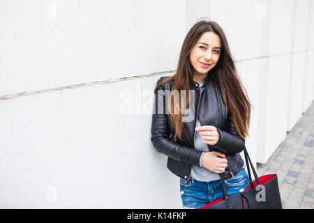 Junge Frau mit Handtasche zu Fuß auf der Straße Stockfoto