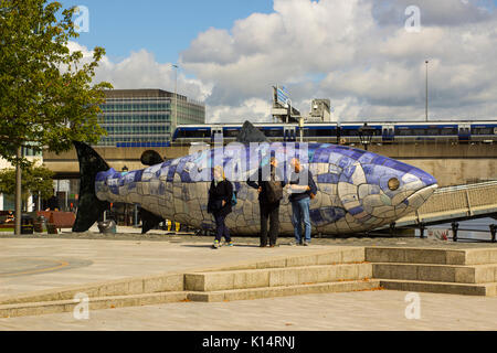 Eine kleine Gruppe von Touristen zusammen Chatten und stellt neben der Lachs des Wissens fisch Skulptur an der Belfaster moderne Donegall Quay vergleichen im Norden Stockfoto