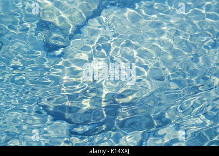 Flachwasser über felsigen Untergrund mit Reflexionen und kleinen plätschernden Wellen Stockfoto