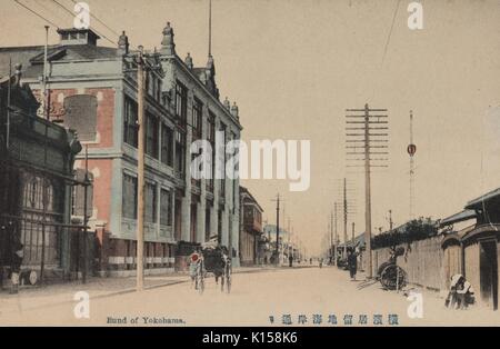 Eine Postkarte von einem getönten Foto erstellt, Gebäude sind im europäischen Stil gehalten, und die Straße mit Utility Pole ausgerichtet ist, können die Menschen auf Karren und auf der Straße gesehen werden, in einem Europäischen Viertel der Bund, Yokohama, Japan, 1912 genannt. Von der New York Public Library. Stockfoto