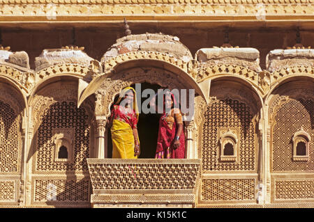 Frauen auf kunstvoll geschnitzten Sandstein Balkon in Jaisalmer Fort, Jaisalmer, Rajasthan, Indien Stockfoto