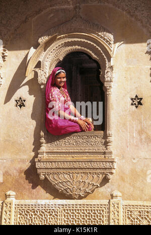Frau sitzt im Fenster der Patwon-ki-Haveli (Haus des Brocade-Händler), Jaisalmer, Rajasthan, Indien Stockfoto
