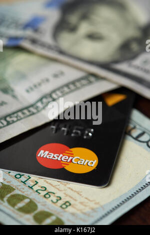 New York, USA - 24. August 2017: Master card Logo in Dollarscheine liegen auf Holz Hintergrund Stockfoto