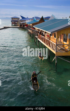 Seezigeuner in hölzernen Kanus verkaufen frische Meeresfrüchte, die den Gästen in Haushalt Dive Resorts auf Mabul Island, Borneo Stockfoto