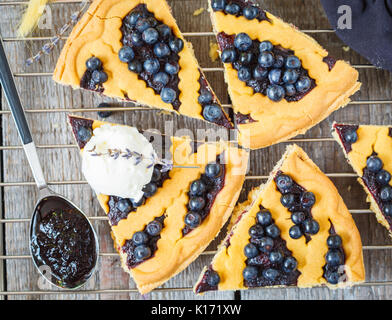 Stücke von hausgemachten öffnen Blueberry Pie mit Vanilleeis auf einer hölzernen Hintergrund, Ansicht von oben, rustikalen Stil. Stockfoto