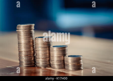 Einsparungen, Erhöhung der Spalten von Goldmünzen, Stapel von Goldmünzen als Grafik auf Holztisch, Business Banking Idee. vintage Ton. Stockfoto