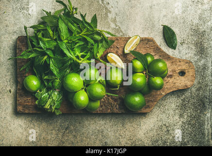 Flatlay frische Limonen und Minze auf Holzbrett Stockfoto