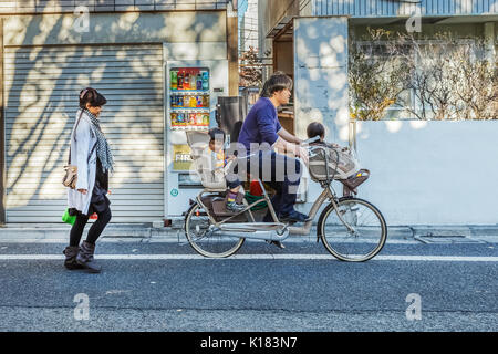 TOKYO, Japan - 23 November: japanische Familie in Tokio, Japan, am 23. November 2013. Unbekannter japanischer Vater mit seinen Kindern auf einem Fahrrad mit Stockfoto