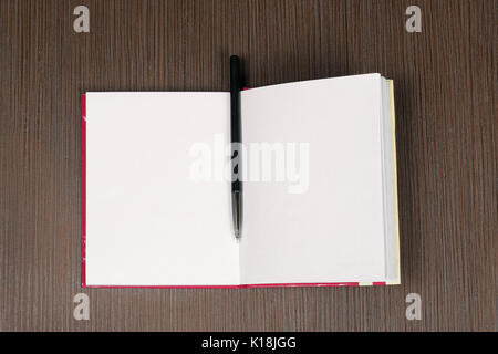 Notebook mit leere weiße Seiten und Stift auf hölzernen Tisch öffnen Stockfoto