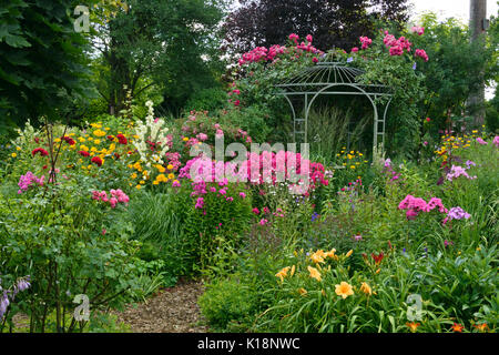 Garten Phlox (Phlox paniculata), Rosen (Rosa) und Taglilien (Hemerocallis) vor einem gartenpavillon. Design: Marianne und Detlef lüdke Stockfoto